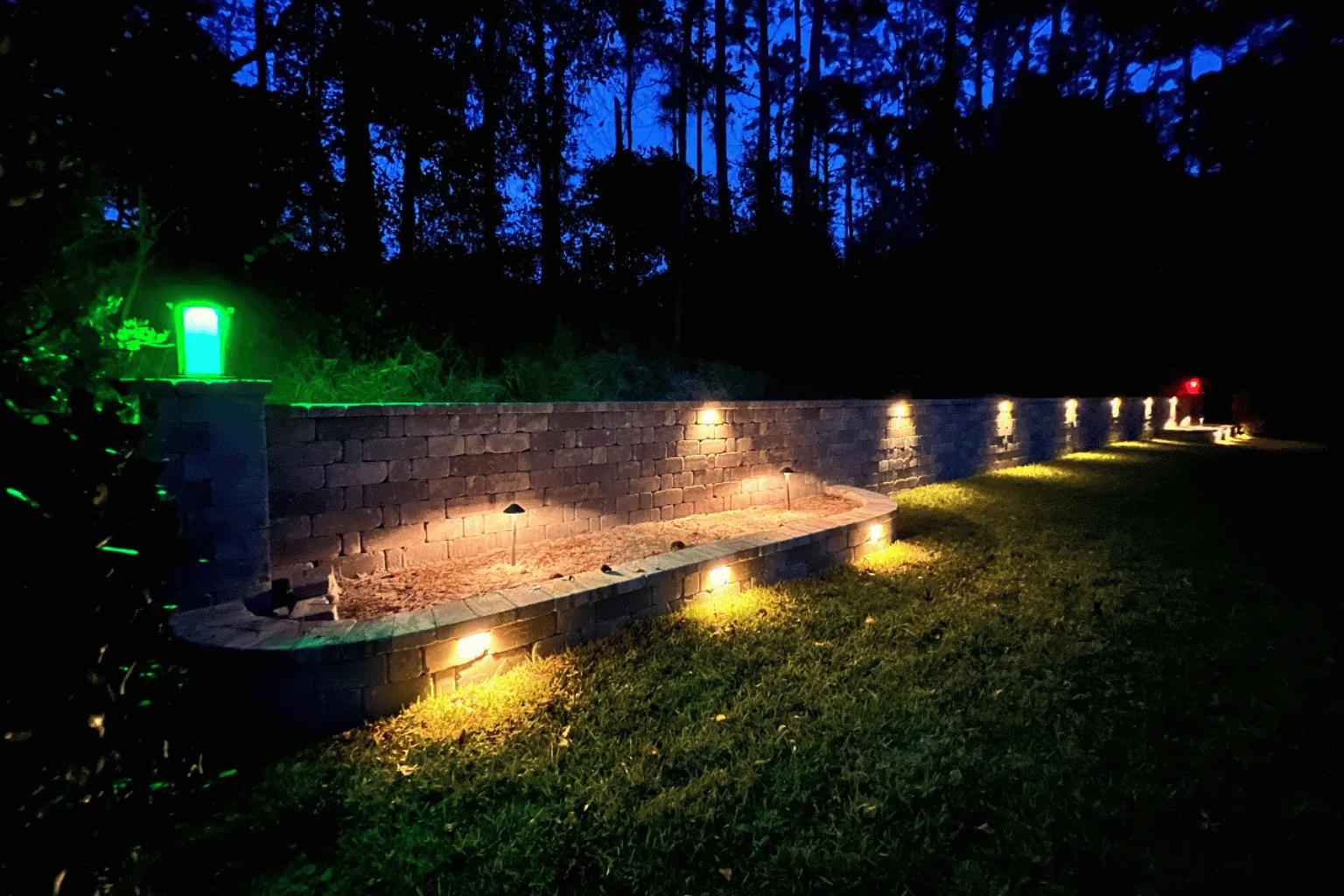 Retaining wall installation with landscape accent lighting by Jax Pavers in Jacksonville FL
