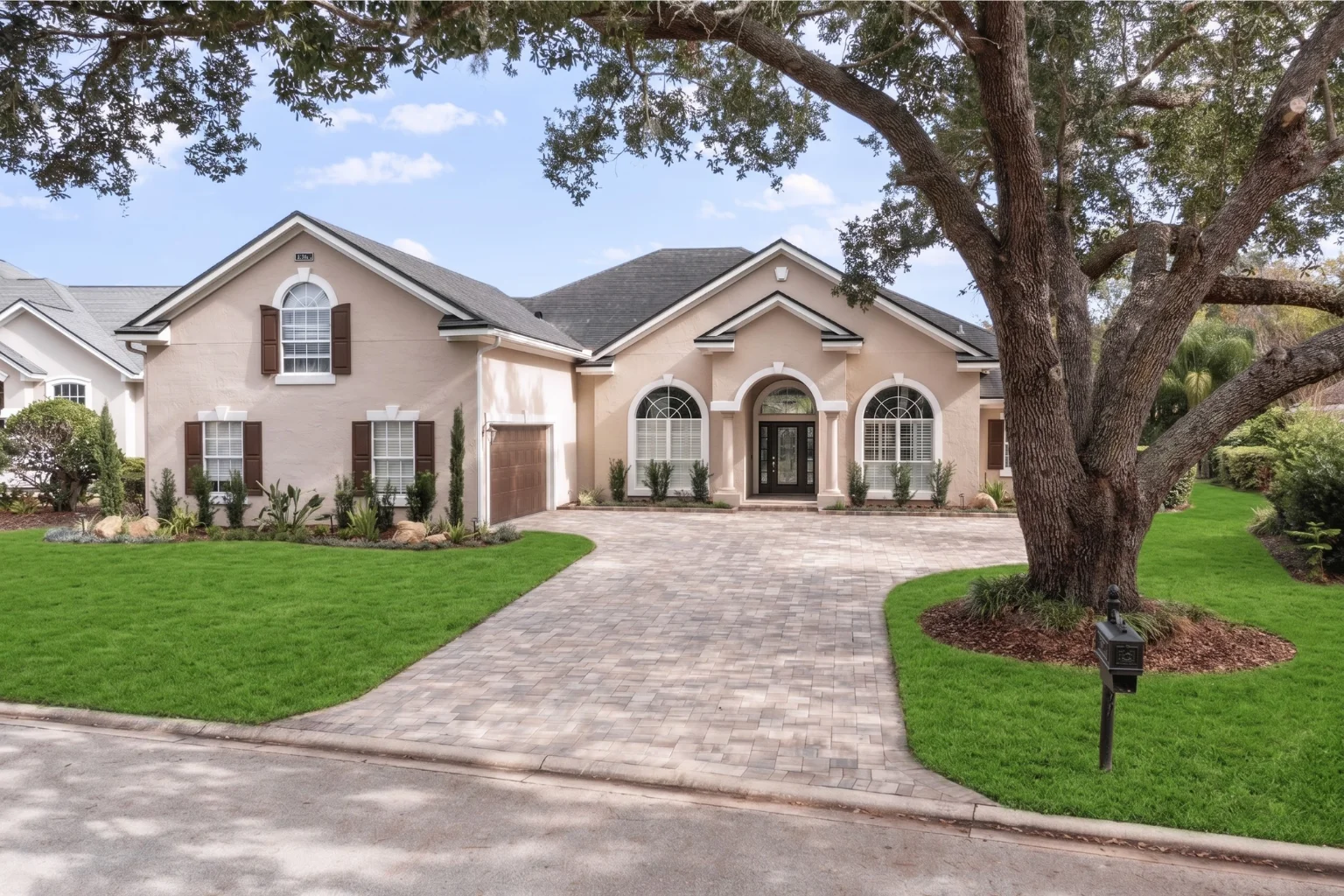 Paver driveway installation at a Jacksonville FL home with mature oak tree by Jax Pavers