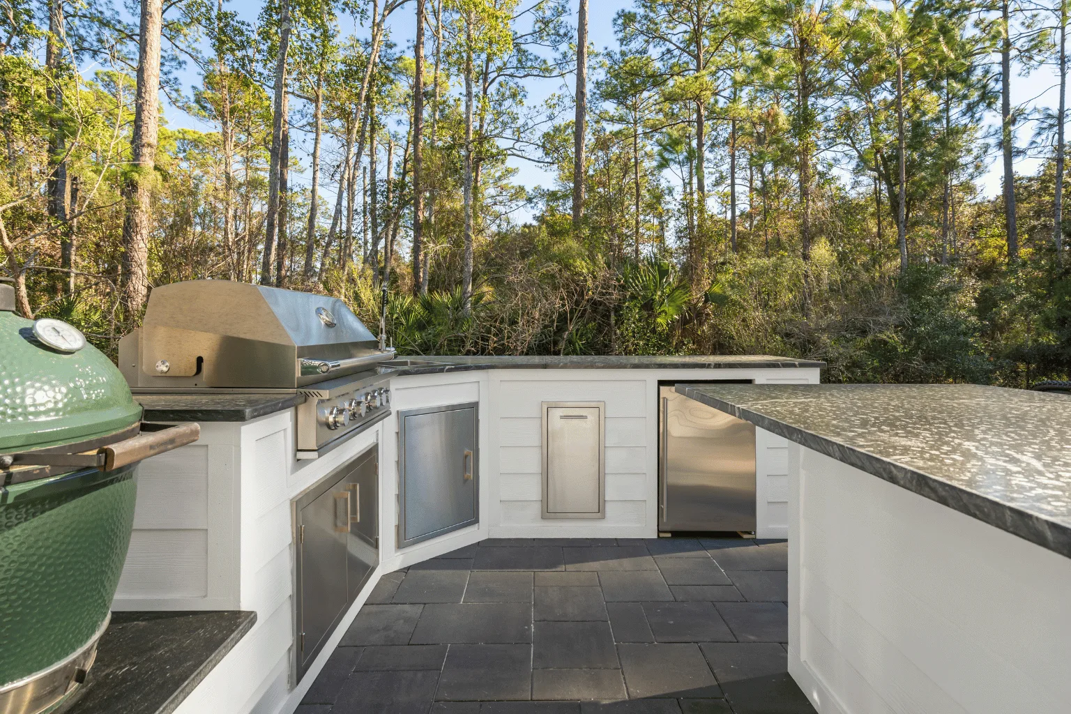 Outdoor kitchen installation with kamado smoker, grill, and refrigerator by Jax Pavers in Jacksonville FL