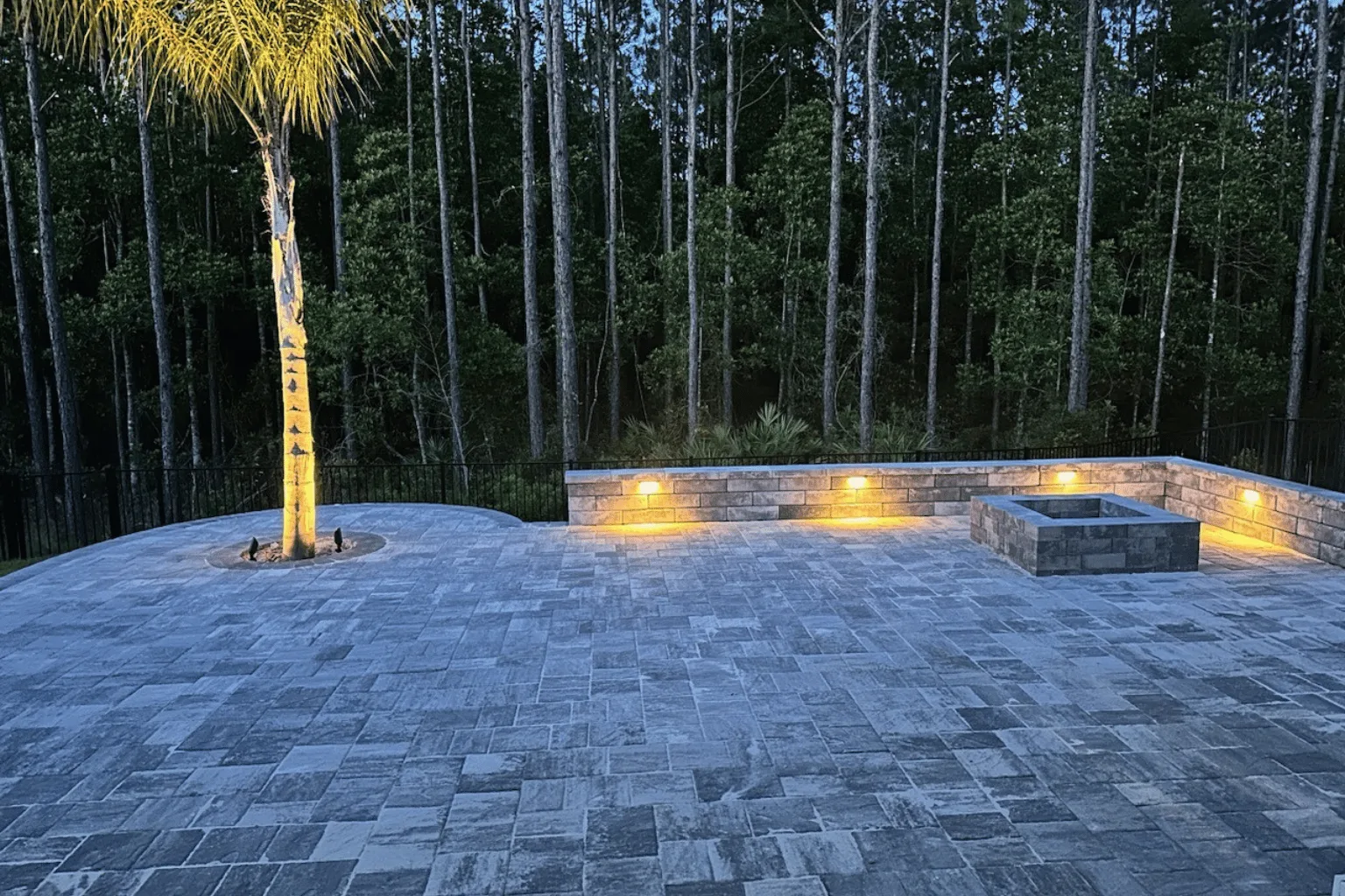 Paver patio and retaining wall installation with built-in accent lighting by Jax Pavers in Jacksonville FL