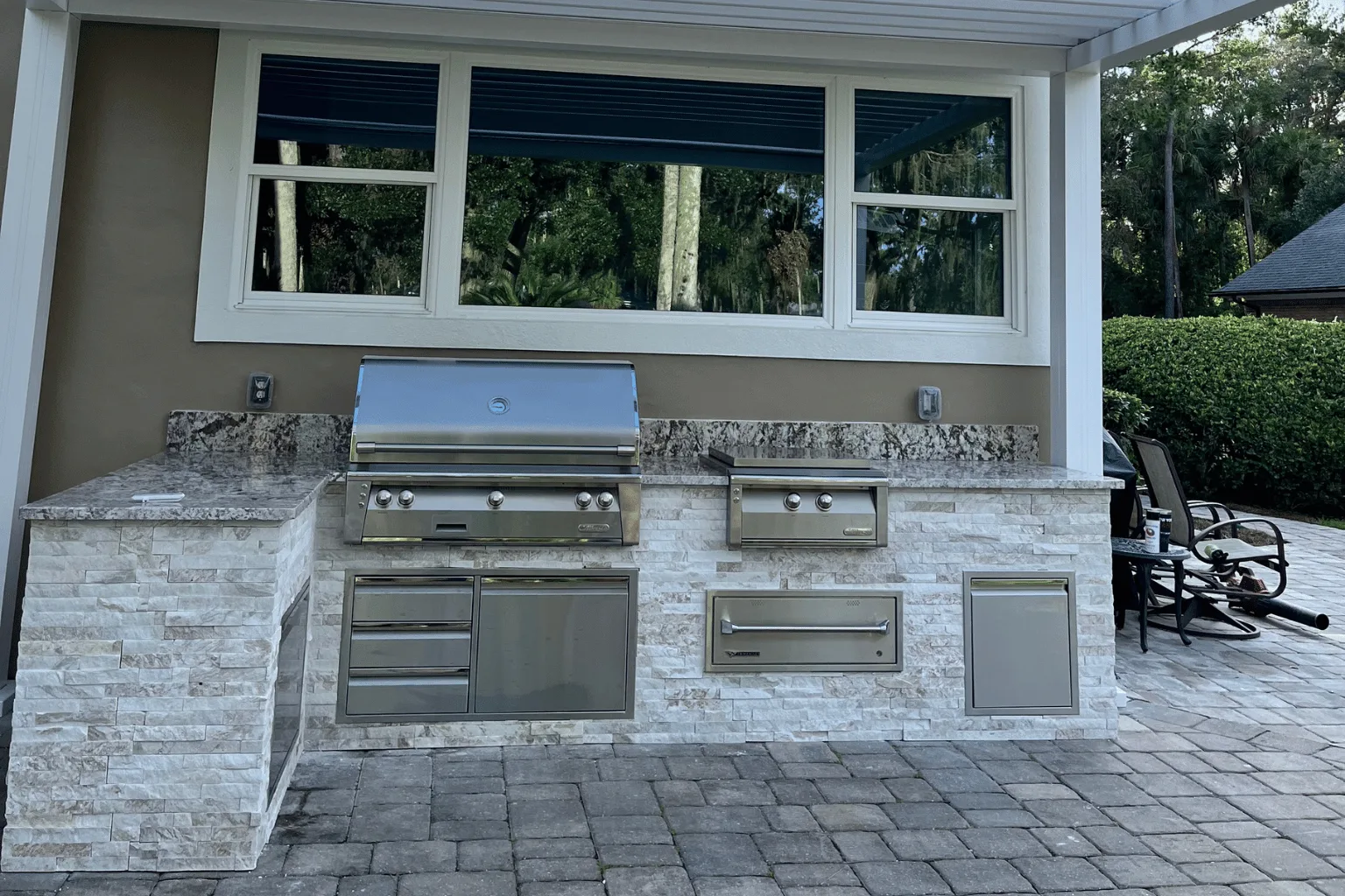 Natural stone veneer outdoor kitchen installation with dual grills by Jax Pavers in Jacksonville FL